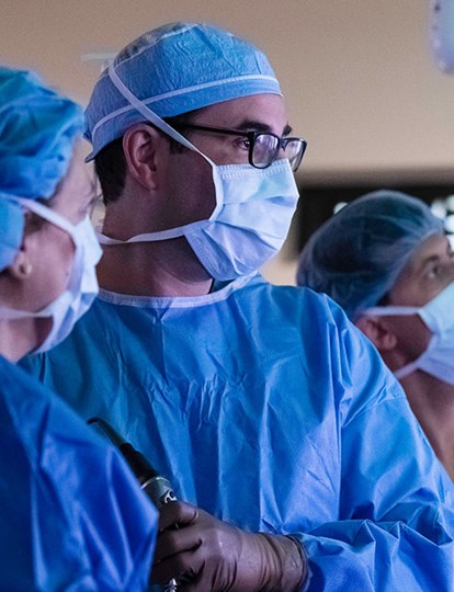 Three MSK Colleagues in operating theatre looking at X rays of brain