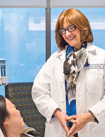 Medical colleague smiling at patient in a bed